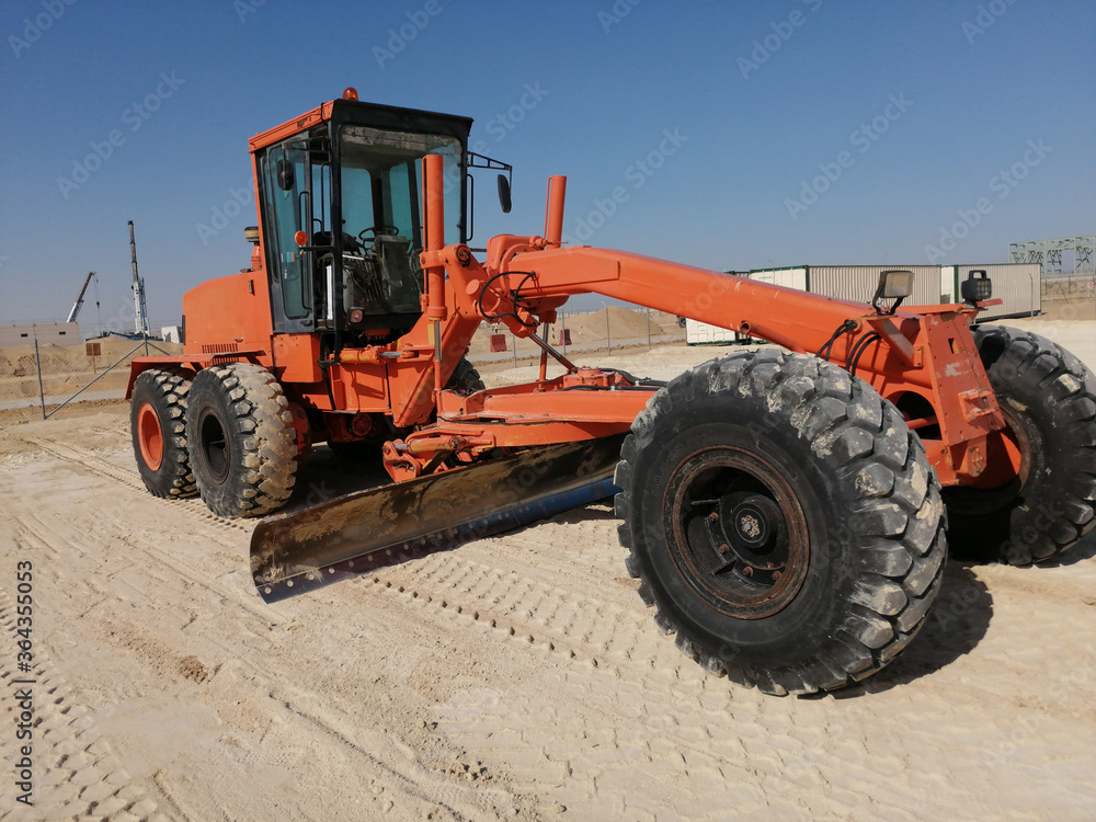 Grader is working on road construction. Using for an equal plain leveling road. A heavy-duty machine is working on site. Grader is working on road construction. Using for an equal plain leveling road. A heavy-duty machine is working on site.