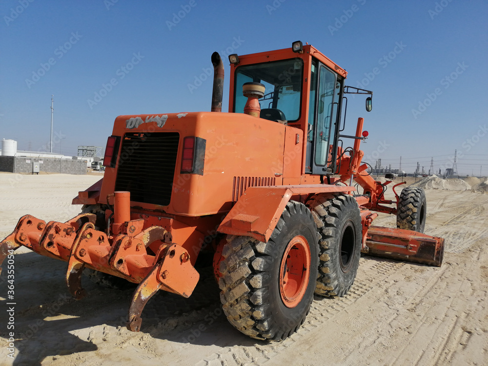 Grader is working on road construction. Using for an equal plain leveling road. A heavy-duty machine is working on site. Grader is working on road construction. Using for an equal plain leveling road. A heavy-duty machine is working on site.