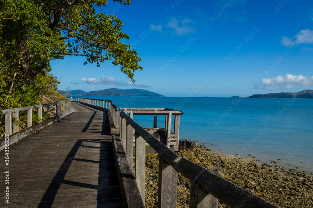 Wooden boardwalk on sunny rocky shores. Daytime, Long Island, Queensland, Australia. 