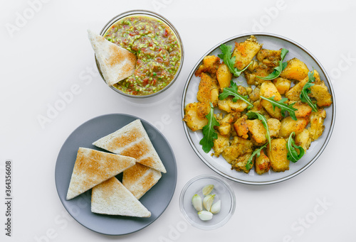 High angle view of baked potatoes guacamole and toasted bread on plate on white background