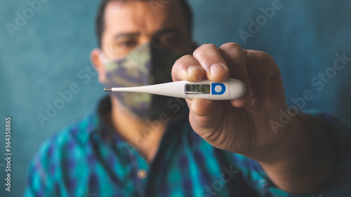 Man with mask in times of COVID-19 taking body temperature