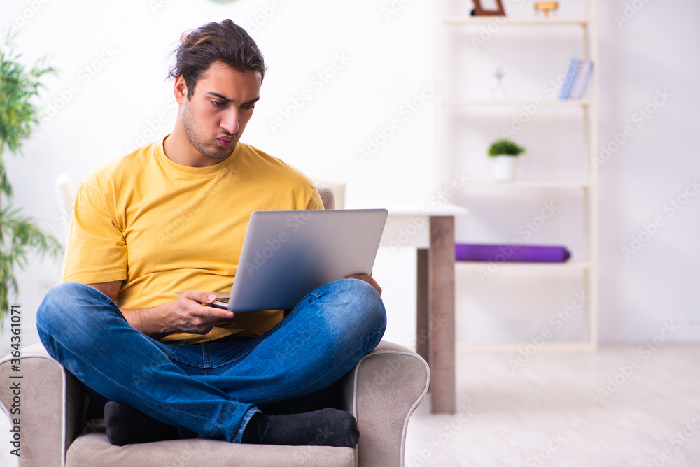 Young handsome man with computer at home