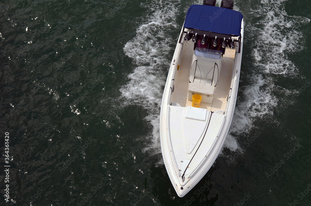 Birds eye view of a white motor boat with blue canvas canopy. Birds eye view of a white motor boat with blue canvas canopy.