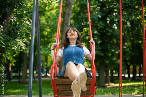 teenager girl happiness female portrait on park outdoor children play ground with swing summer day