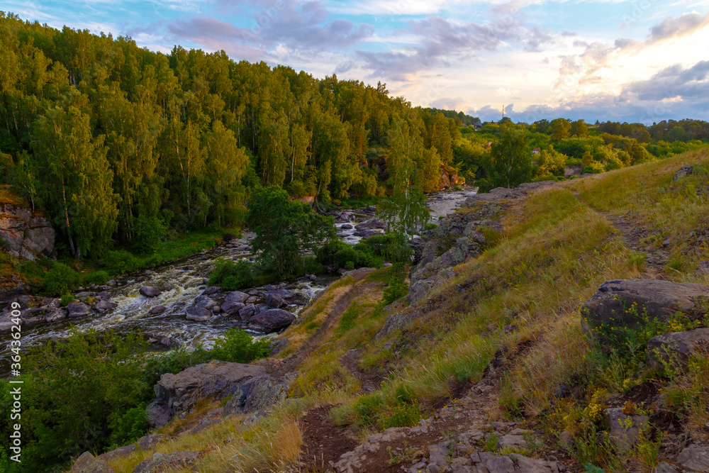 swirling streams of mountain river with rocky shore in a beautiful valley in forest, top view. swirling streams of mountain river with rocky shore in a beautiful valley in forest, top view.