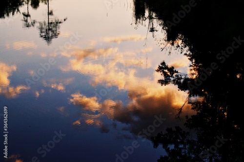 Clouds reflected in water with ripples during sunset