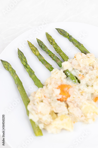 Cooked asparagus witl dill sauce served on the plate photo