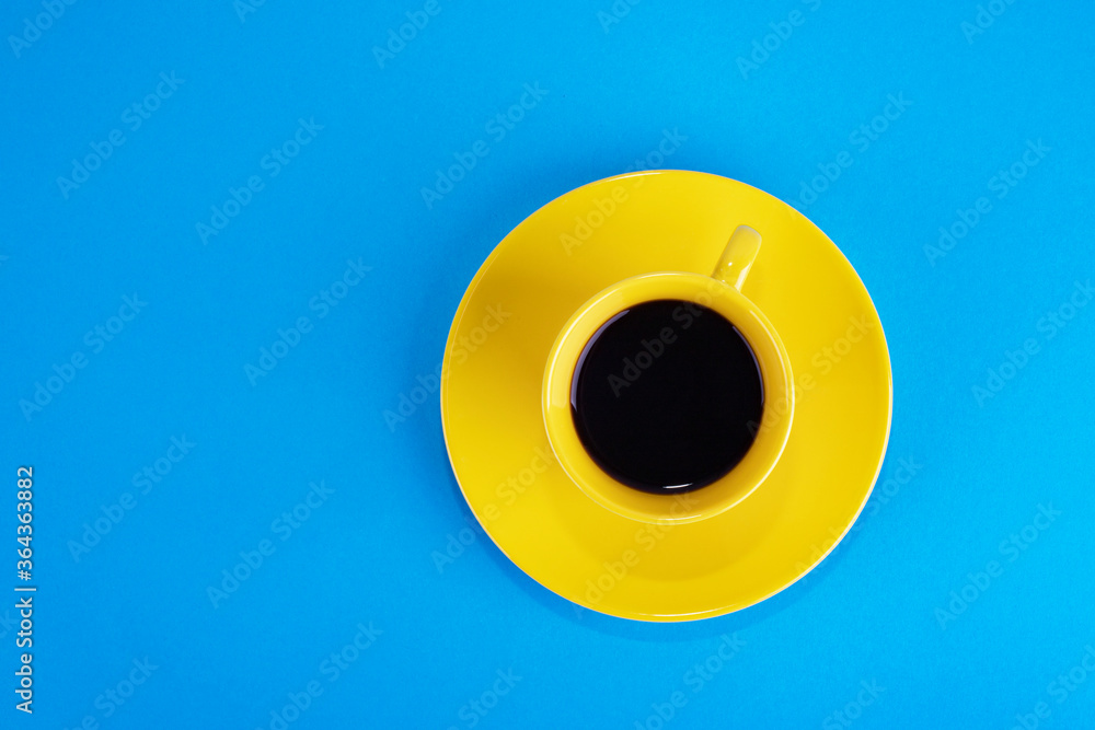 Yellow cup with aromatic coffee on a blue background Yellow cup with aromatic coffee on a blue background