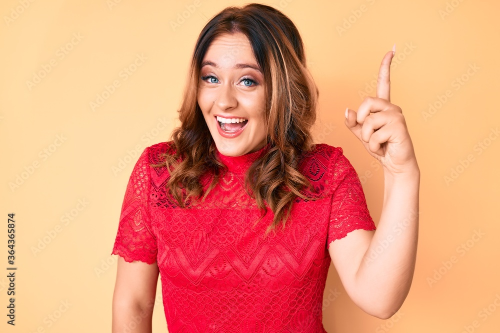 Young beautiful caucasian woman wearing casual clothes pointing finger up with successful idea. exited and happy. number one. Young beautiful caucasian woman wearing casual clothes pointing finger up with successful idea. exited and happy. number one.
