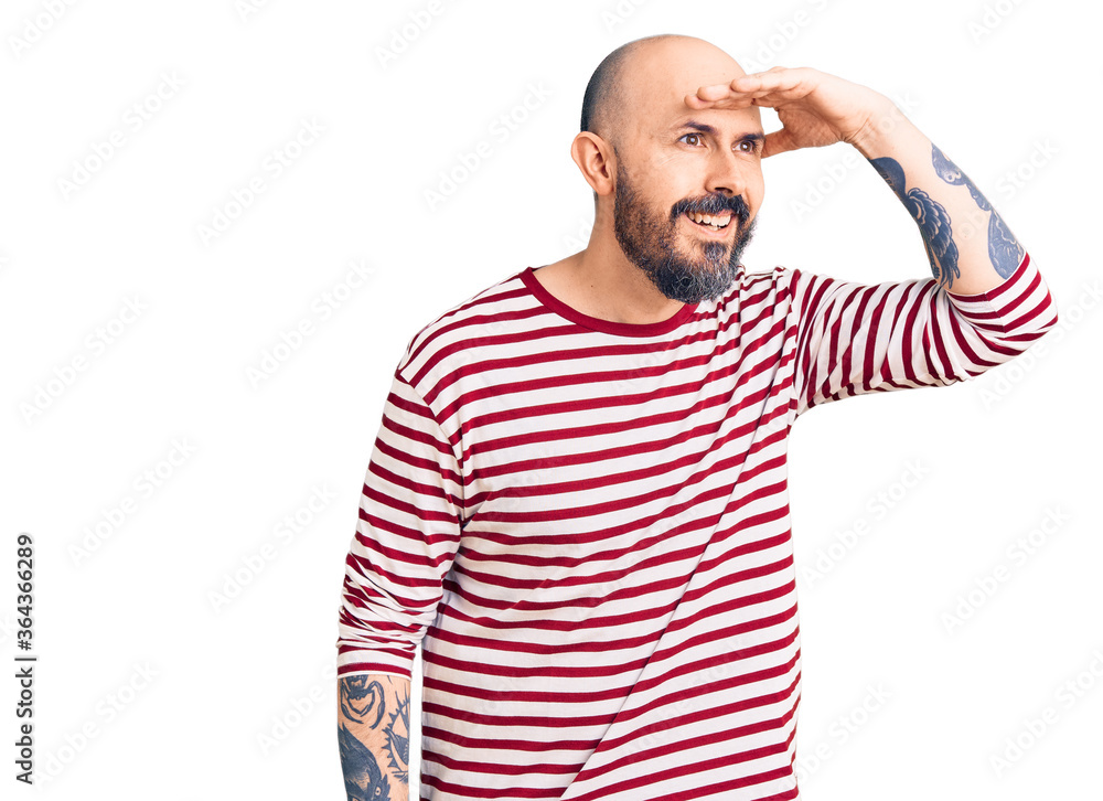 Young handsome man wearing casual clothes very happy and smiling looking far away with hand over head. searching concept. Young handsome man wearing casual clothes very happy and smiling looking far away with hand over head. searching concept.