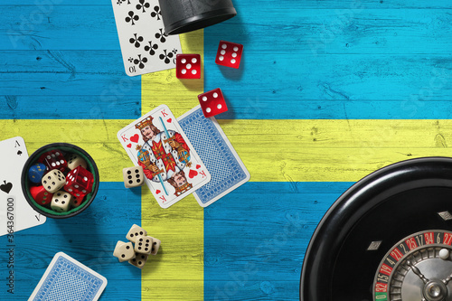 Sweden casino theme. Aces in poker game, cards and chips on red table with national wooden flag background. Gambling and betting. photo