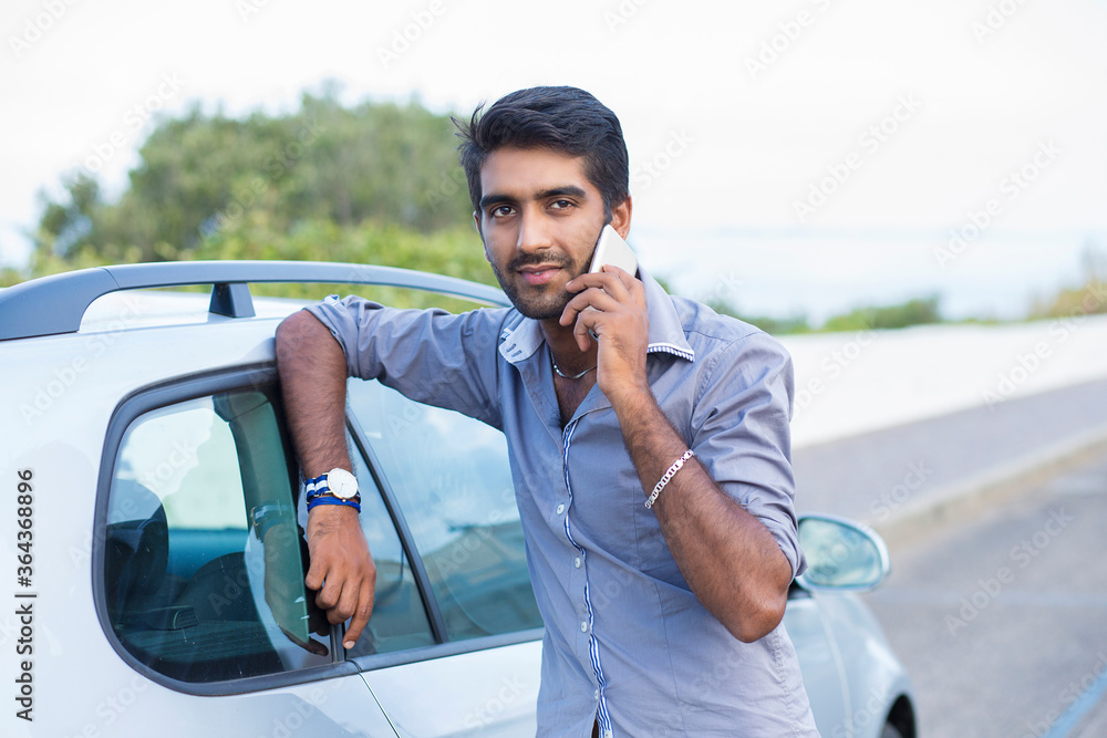 Naklejka premium Happy handsome young man talking on mobile phone