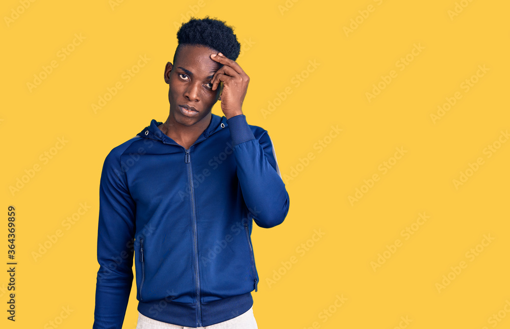 Young african american man wearing sportswear worried and stressed about a problem with hand on forehead, nervous and anxious for crisis Young african american man wearing sportswear worried and stressed about a problem with hand on forehead, nervous and anxious for crisis