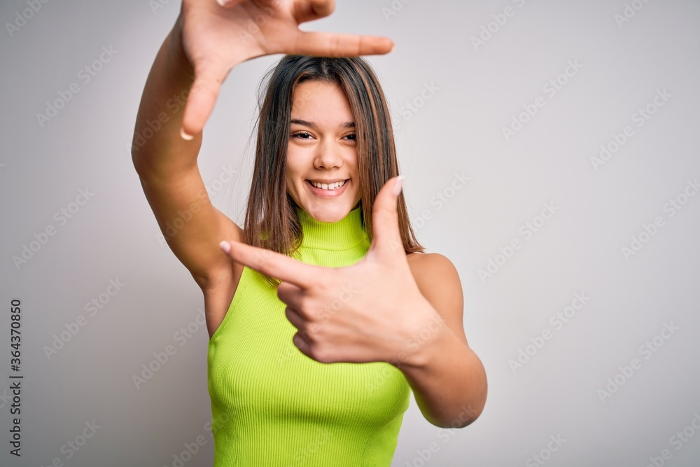 Young beautiful brunette girl wearing casual summer t-shirt over isolated white background smiling making frame with hands and fingers with happy face. Creativity and photography concept. Young beautiful brunette girl wearing casual summer t-shirt over isolated white background smiling making frame with hands and fingers with happy face. Creativity and photography concept.