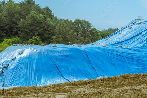 Dirt covered with blue tarp
