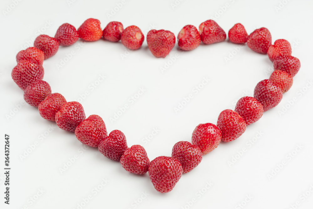 heart is laid out of strawberries on a white background heart is laid out of strawberries on a white background