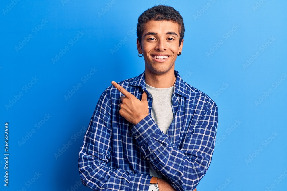 Young african amercian man wearing casual clothes smiling cheerful pointing with hand and finger up to the side Young african amercian man wearing casual clothes smiling cheerful pointing with hand and finger up to the side