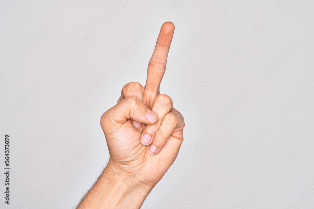 Hand of caucasian young man showing fingers over isolated white background showing provocative and rude gesture doing fuck you symbol with middle finger