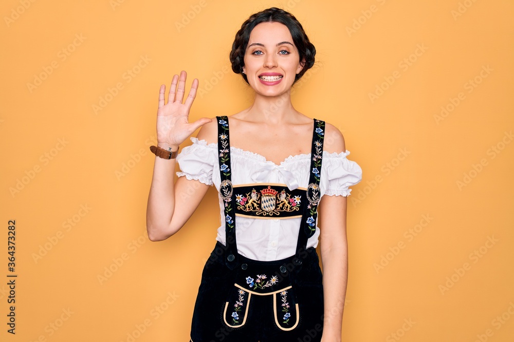 Young beautiful german woman with blue eyes wearing traditional octoberfest dress showing and pointing up with fingers number five while smiling confident and happy. Young beautiful german woman with blue eyes wearing traditional octoberfest dress showing and pointing up with fingers number five while smiling confident and happy.