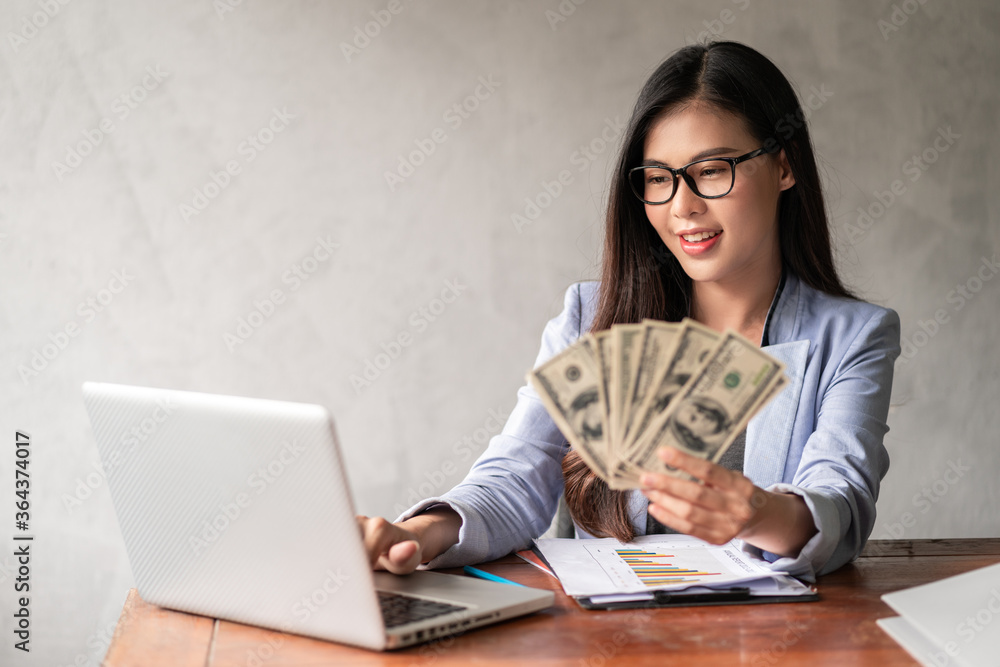 Dollar in a businesswoman hand. An Asia woman is working from home or office and glad to get dollar money from work and from a supplementary career or Part-time self-employment. Dollar in a businesswoman hand. An Asia woman is working from home or office and glad to get dollar money from work and from a supplementary career or Part-time self-employment.