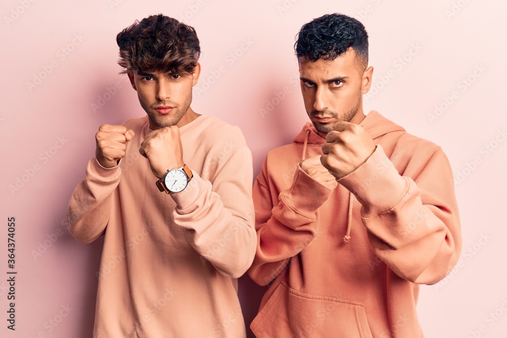 Young gay couple wearing casual clothes ready to fight with fist defense gesture, angry and upset face, afraid of problem Young gay couple wearing casual clothes ready to fight with fist defense gesture, angry and upset face, afraid of problem