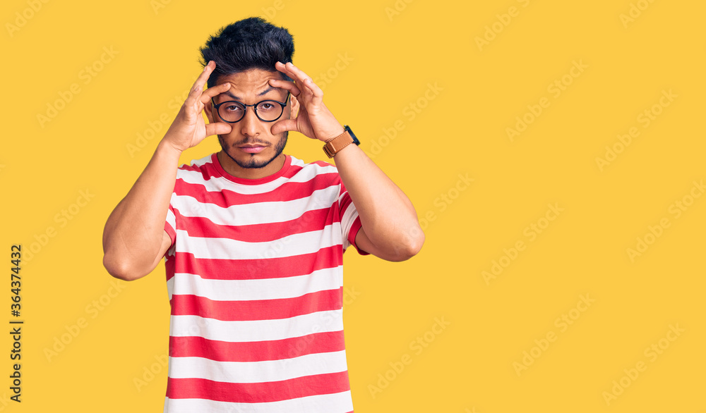 Handsome latin american young man wearing casual clothes and glasses trying to open eyes with fingers, sleepy and tired for morning fatigue Handsome latin american young man wearing casual clothes and glasses trying to open eyes with fingers, sleepy and tired for morning fatigue