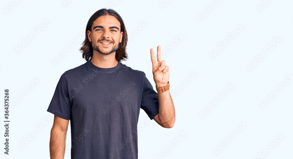 Young handsome man wearing casual clothes smiling with happy face winking at the camera doing victory sign. number two. Young handsome man wearing casual clothes smiling with happy face winking at the camera doing victory sign. number two.
