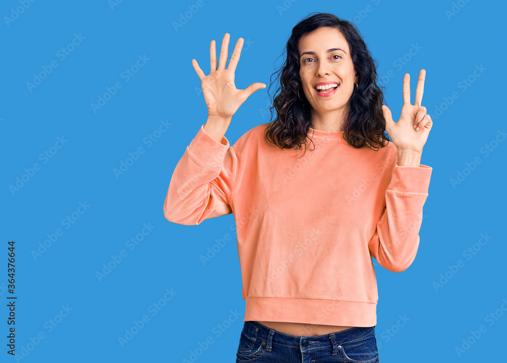 Young beautiful hispanic woman wearing casual clothes showing and pointing up with fingers number eight while smiling confident and happy. Young beautiful hispanic woman wearing casual clothes showing and pointing up with fingers number eight while smiling confident and happy.