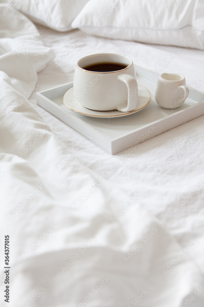Cozy breakfast in bed, cup of coffee and milk on the grey fabric, space for text. Alarm clock for seven in the morning. Cozy breakfast in bed, cup of coffee and milk on the grey fabric, space for text. Alarm clock for seven in the morning.