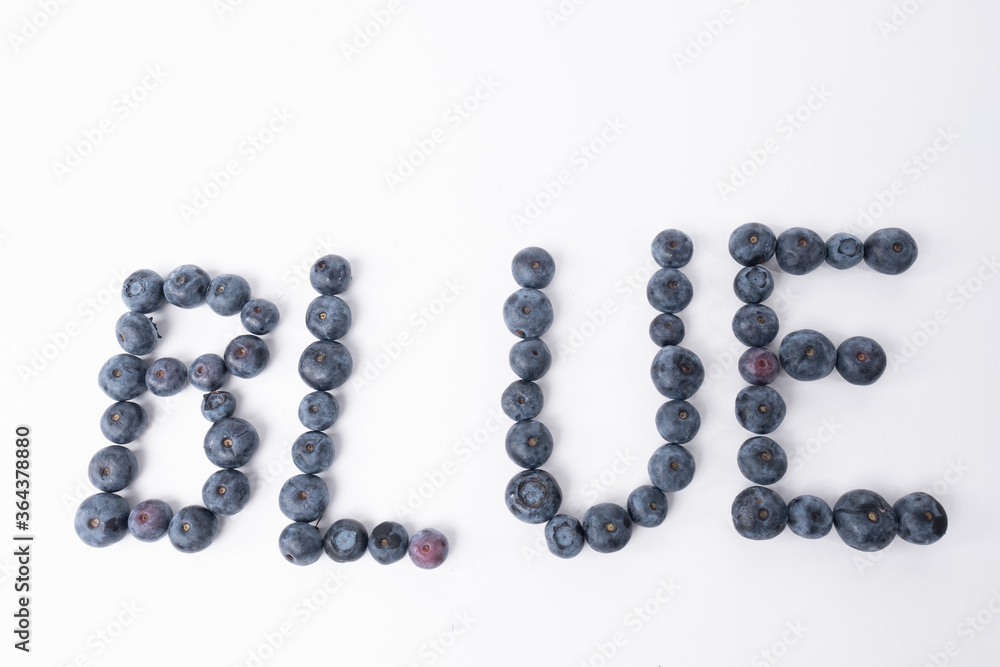 Blueberries arranged on a whithe background to spell the word blue Blueberries arranged on a whithe background to spell the word blue