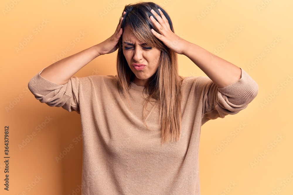 Young beautiful woman wearing casual sweater with hand on head, headache because stress. suffering migraine. Young beautiful woman wearing casual sweater with hand on head, headache because stress. suffering migraine.