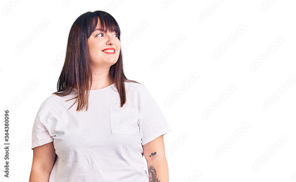 Young plus size woman wearing casual clothes looking away to side with smile on face, natural expression. laughing confident. Young plus size woman wearing casual clothes looking away to side with smile on face, natural expression. laughing confident.