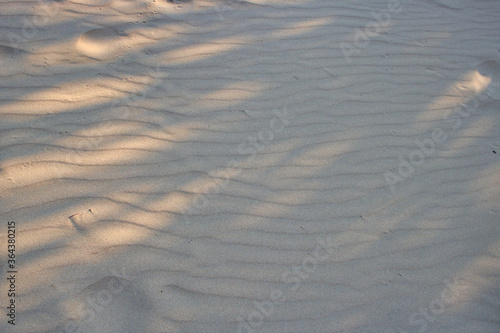 This unique photo shows the sand structure on a beach in Thailand with sunlight and shade. the picture was taken at noon.