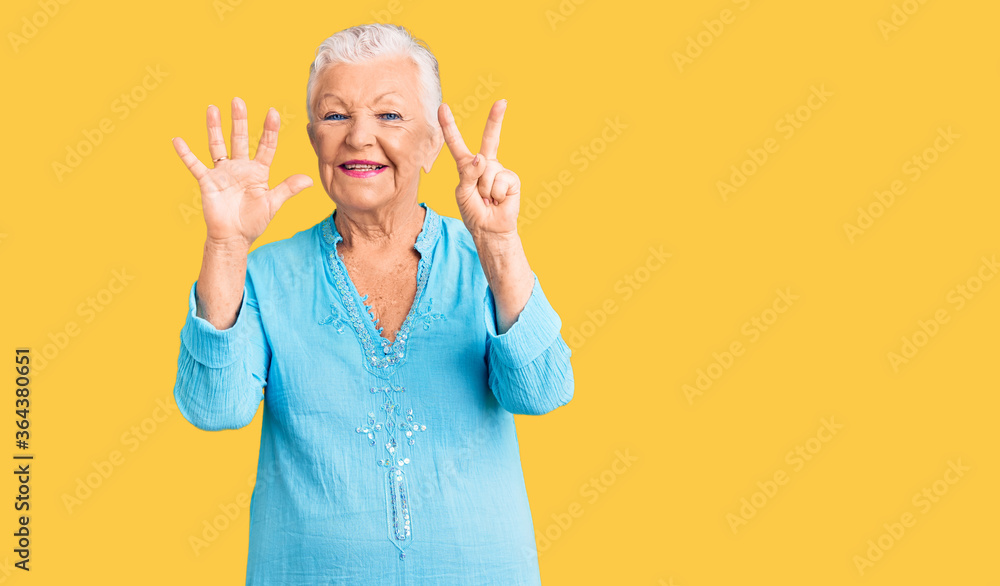 Senior beautiful woman with blue eyes and grey hair wearing summer dress showing and pointing up with fingers number seven while smiling confident and happy. Senior beautiful woman with blue eyes and grey hair wearing summer dress showing and pointing up with fingers number seven while smiling confident and happy.