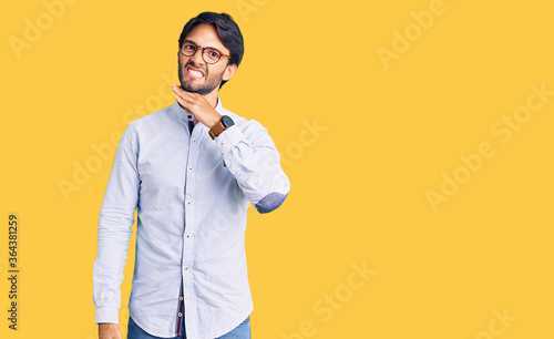 Handsome hispanic man wearing business shirt and glasses cutting throat with hand as knife, threaten aggression with furious violence photo