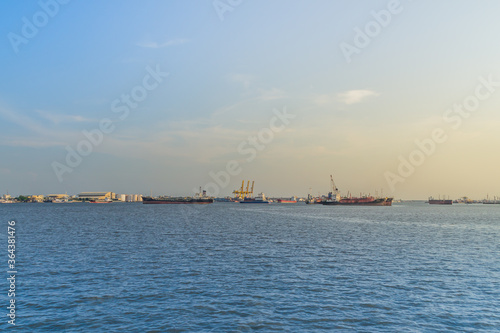Massive container ship for import export and business logistic. Big cargo ship is leaving from Bangkok Port Authority of Thailand or Klong Toey port along Chao Phraya river in Bangkok,Thailand.