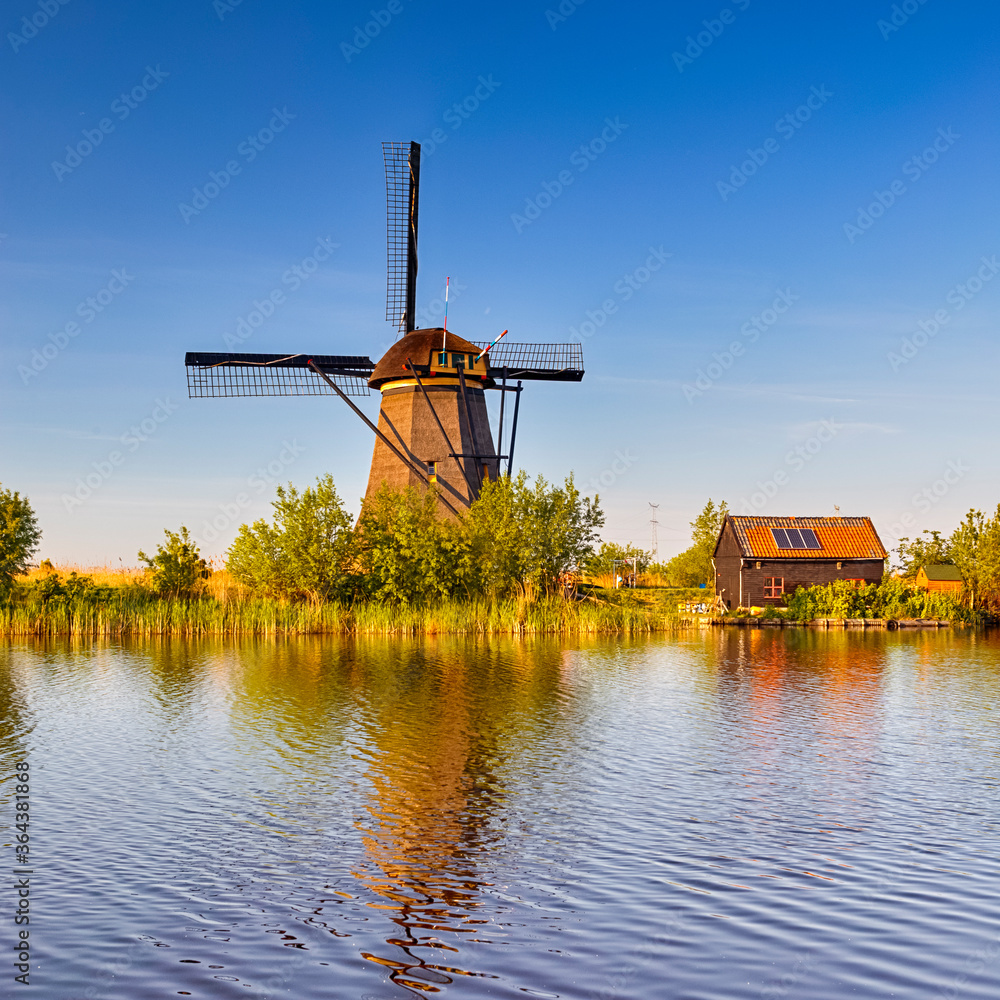 Netherlands Traveling. Traditional Dutch Windmill and House in Kinderdijk Village in the Netherlands At Daytime.