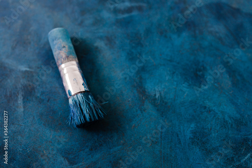 brush on top of finished work of an abstract textured painting or photography backdrop with blue and black tones