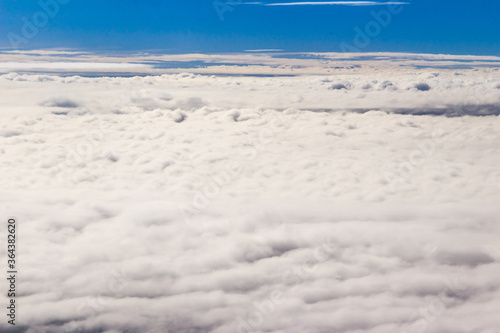 Beautiful cloudscape and blue sky from aerial view  nature view from above the sky and clouds. White clouds and blue sky view like the heaven from airplane window. Sunlight in the sky shines on clouds