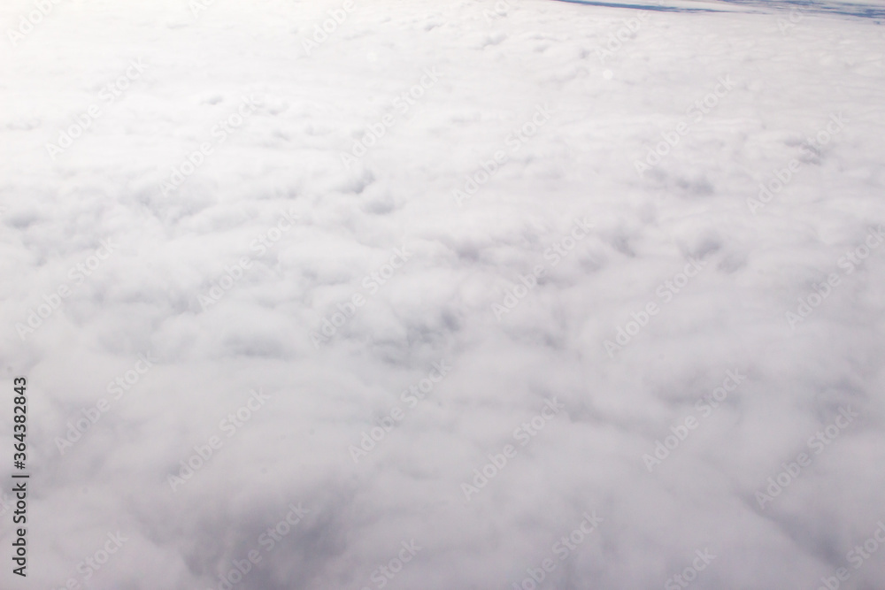 Beautiful cloudscape and blue sky from aerial view, nature view from above the sky and clouds. White clouds and blue sky view like the heaven from airplane window. Sunlight in the sky shines on clouds