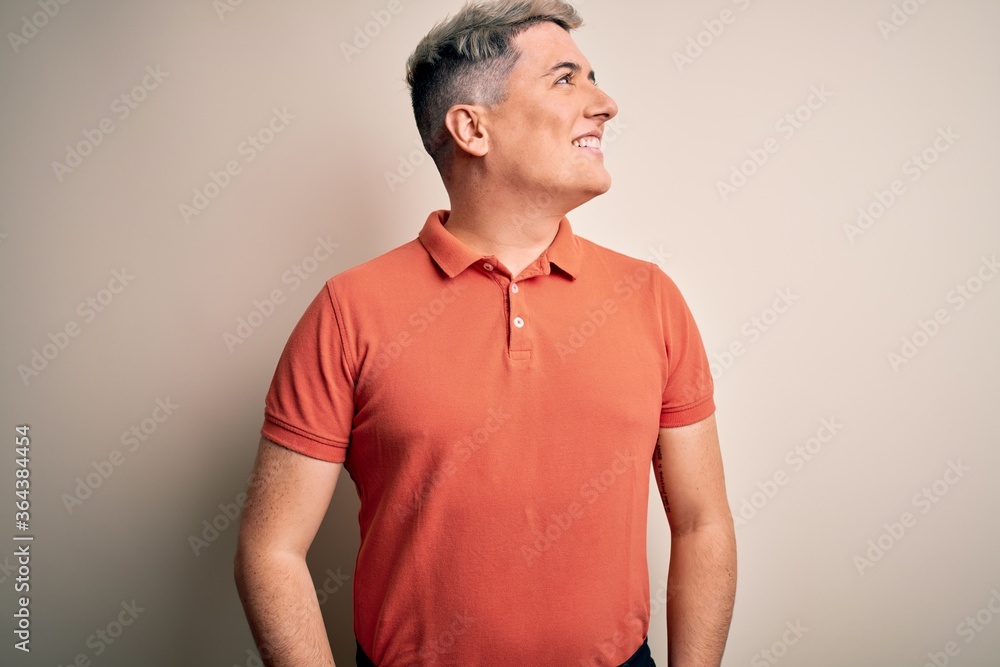 Young handsome modern man standing over isolated background looking away to side with smile on face, natural expression. Laughing confident. Young handsome modern man standing over isolated background looking away to side with smile on face, natural expression. Laughing confident.