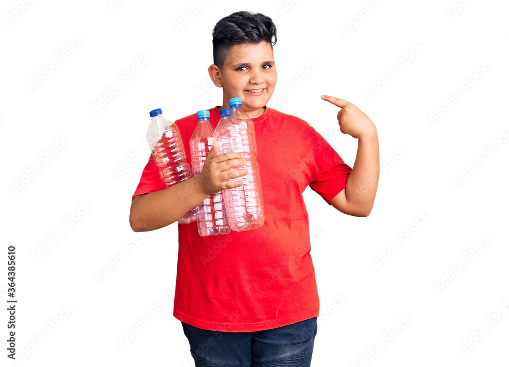 Little boy kid holding recycling plastic bottles pointing finger to one self smiling happy and proud Little boy kid holding recycling plastic bottles pointing finger to one self smiling happy and proud