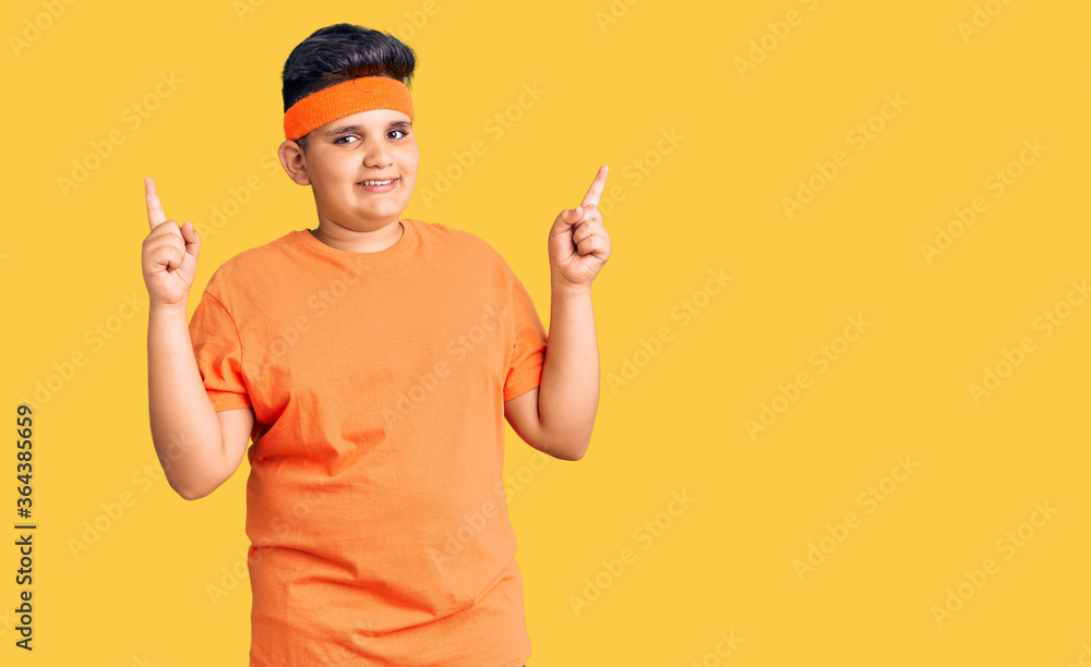 Little boy kid wearing sportswear smiling confident pointing with fingers to different directions. copy space for advertisement