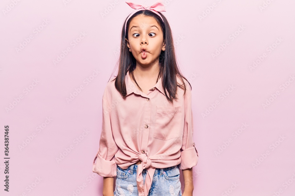 Beautiful child girl wearing casual clothes making fish face with lips, crazy and comical gesture. funny expression. Beautiful child girl wearing casual clothes making fish face with lips, crazy and comical gesture. funny expression.