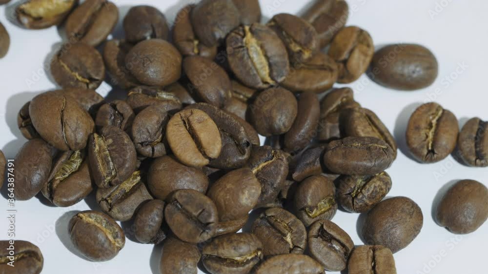 Dark Coffee beans rotating. Close up of roasted coffee beans on white background. Shallow depth of field Dark Coffee beans rotating. Close up of roasted coffee beans on white background. Shallow depth of field