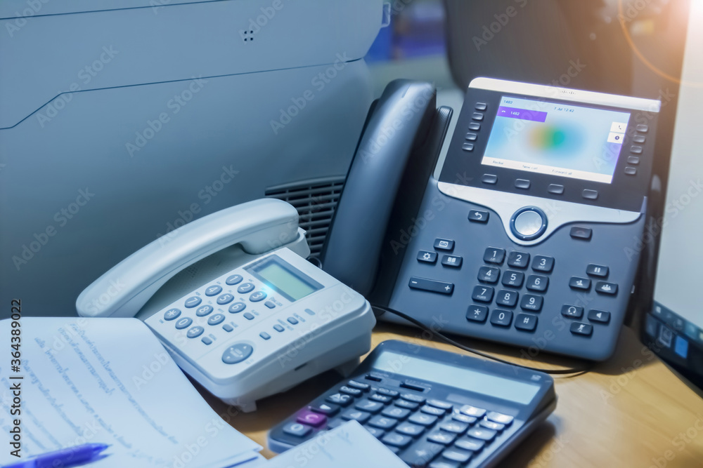 Close up soft focus on telephone devices with copy space background at call center office desk in workspace room and computer for customer service support communication & technology concept. Close up soft focus on telephone devices with copy space background at call center office desk in workspace room and computer for customer service support communication & technology concept.