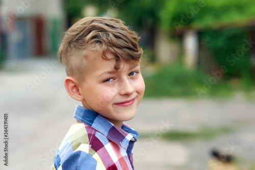 Portrait of a little boy with a fashionable hairstyle on the street