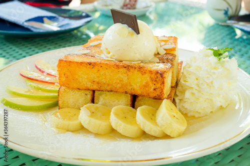 Toast and ice cream are placed on top, paired with bananas and apples.