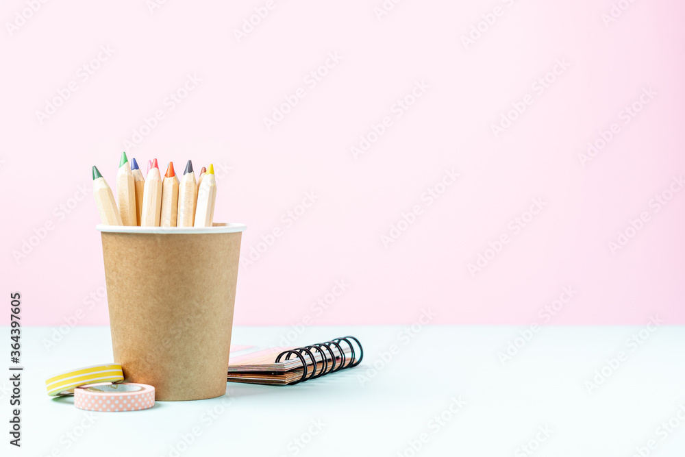 Back to school banner with pencil in a cup of coffee. School supplies and stationery, other elements in pink mint empty background with space for text Back to school banner with pencil in a cup of coffee. School supplies and stationery, other elements in pink mint empty background with space for text