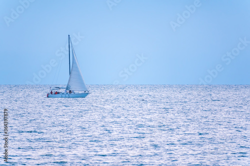 Sailing yacht in the blue calm sea.